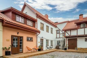 una casa con un patio con sillas y mesas en B2 Apartments, en Klaipėda
