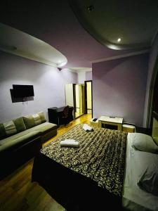 a hotel room with a bed and a couch at Lux Palace Hotel in Kutaisi