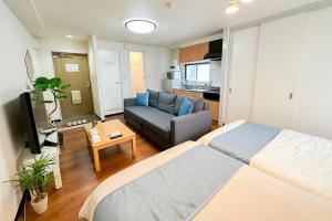 a hotel room with two beds and a couch at ユニオン新大阪 十三駅西中島南方駅 自転車&wifi貸出無料 in Osaka