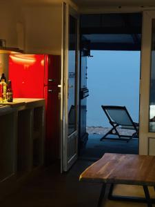 a kitchen with a red refrigerator and a table at Cave Beach House Milos in Provatas