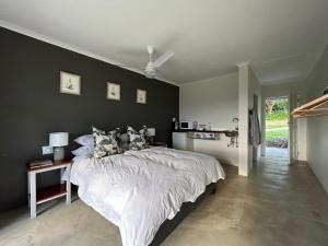 a bedroom with a large bed and a wall at Clearwater Farm Venue in Port Edward