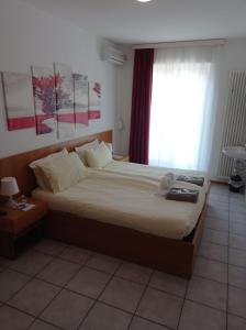 a bedroom with a large bed with a window at Hotel Ristorante Camoghe in Isone