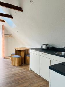 une cuisine avec des placards blancs et un comptoir dans l'établissement MariaDora, à Alter Graben
