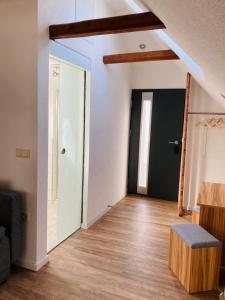 sala de estar con puerta negra y suelo de madera en MariaDora, en Alter Graben