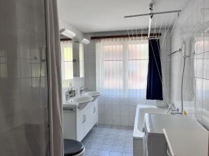 萨斯格伦德apartment Alpenrose的带两个水槽、一个浴缸和一个马桶的浴室