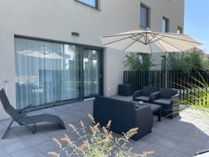 a patio with two chairs and an umbrella at Apartmány ROSE Mikulov in Mikulov