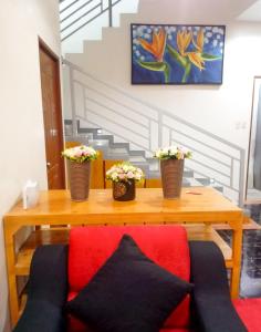Guinobatan的住宿－Majestique Hotel Albay Bicol，一张木桌,上面有两朵盆花