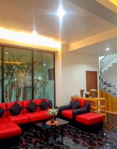 Majestique Hotel Albay Bicol في Guinobatan: غرفة معيشة مع كنب احمر وطاولة