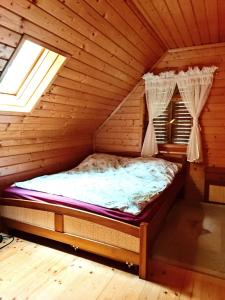 a bed in a room in a log cabin at Dom Wypoczynkowy Windmill in Kopalino