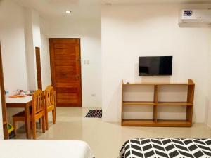 a living room with a table and a television and a room at Majestique Hotel Albay Bicol in Guinobatan