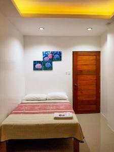 a bedroom with a bed and a wooden door at Majestique Hotel Albay Bicol in Guinobatan