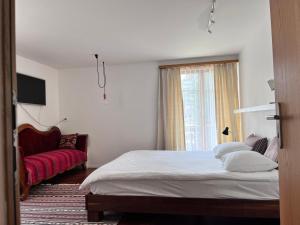 a bedroom with a bed and a window and a couch at apartment Alpenrose in Saas-Grund