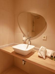 a bathroom with a white sink and a mirror at Ibis Styles Mayotte Aéroport in Pamandzi