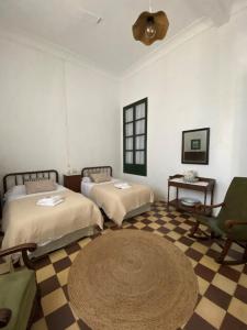 Zimmer mit 2 Betten, einem Tisch und einem Ventilator in der Unterkunft Real Fundición de Alcora in Canjáyar