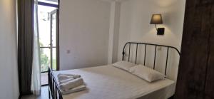 een slaapkamer met een bed met witte lakens en een raam bij Batumi-Gonio First line Apartment in Gonio