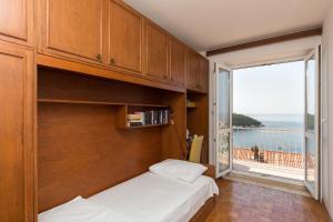 ein Schlafzimmer mit einem Bett und einem großen Fenster in der Unterkunft Beautiful Nest Rooms in Dubrovnik