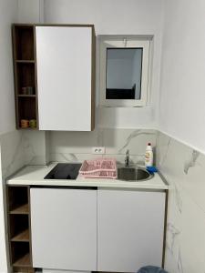 Una cocina blanca con fregadero y ventana. en Bora Lindi Ulcinj apartments, en Ulcinj 37 fotos más