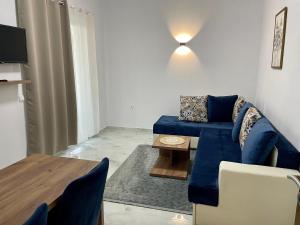 a living room with a blue couch and a table at Bora Lindi Ulcinj apartments in Ulcinj