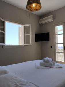 1 dormitorio con 1 cama con toallas en Paradise Hotel, en Koufonisia