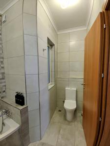 y baño con aseo y lavamanos. en Deggies Apartments - spacious, modern apartment!, en Naxxar