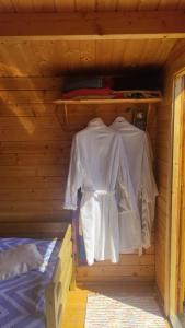 a wooden cabin with white shirts in it at Sillaotsa Puhkemaja in Vaisi