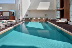 a swimming pool in a hotel with lounge chairs at Marriott Hotel Downtown Abu Dhabi in Abu Dhabi