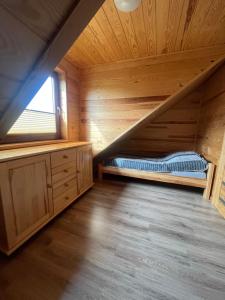 a log cabin with a bed in the attic at Rajski Zakątek in Chłopy