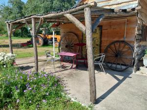 a wooden cabin with a table and aokedoked wheel and chairs at La chouette étoilée in Auxon