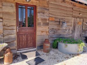une porte en bois d'une maison avec un pot de fleurs dans l'établissement La chouette étoilée, à Auxon