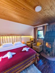a bedroom with a large bed and a fireplace at Ethno village Montenegro Brezna in Plužine