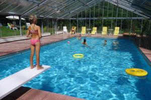 una chica en bikini parada en una piscina con frisbees en Residence Klementhof 1 en Fiumes