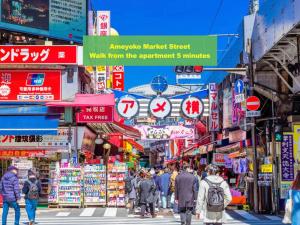 a crowd of people walking down a street in an asian market at 上野浅草銀座近い 山手線御徒町駅3分 アメ横3分 上野駅10分 上野広小路駅3分 湯島駅2分 2-4人 レトロ和風畳寝室 in Tokyo