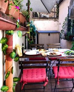 a table with pink cushioned chairs on a patio at Spagna Rooms in Rome