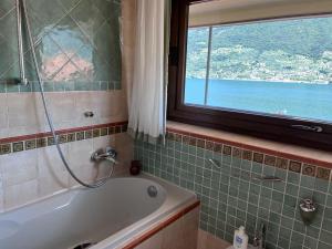 a bathroom with a bath tub and a window at Villetta la Colombaia in Carzano