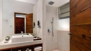 a bathroom with a white sink and a mirror at Lynnaya Urban River Resort in Siem Reap