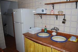 a kitchen counter with two sinks and a refrigerator at El rinconcito in Fuenteheridos +21 photos