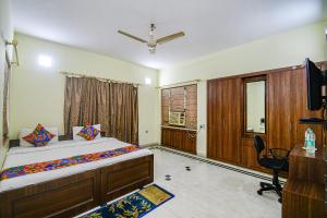 a bedroom with a bed and a desk and a television at FabExpress Ullash Residency in Kolkata