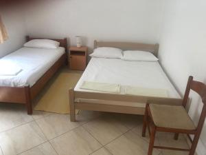 two beds in a room with a table and a chair at Nafija in Donji Štoj