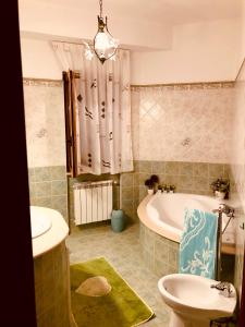 a bathroom with a tub and a toilet and a sink at Villa Aurora in Mandatoriccio Marina