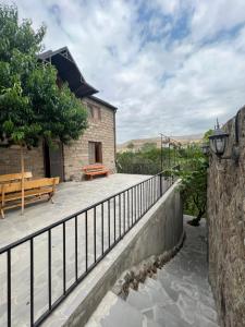 a building with a fence and a bench on a balcony at Dinadav house in Garni