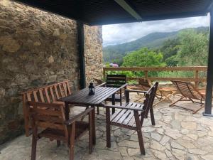 ein Holztisch und Stühle auf einer Terrasse in der Unterkunft Casa da Oliveira in Cariño + 37 Fotos