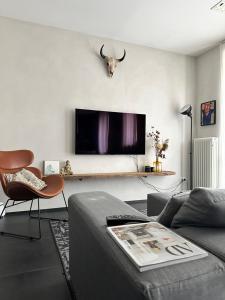 a living room with a tv with a cow head on the wall at Loft al mare Porto San Giorgio in Porto San Giorgio