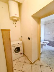 a bathroom with a washing machine and a toilet at Casina Tecla in Cavo
