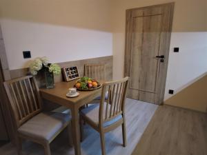 a dining room table with a bowl of fruit on it at Apartmány Čechie in Janske Lazne +13 photos