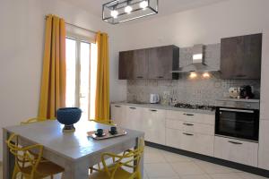 cocina con mesa con sillas y comedor en Casa vacanza Luna, en Cassibile