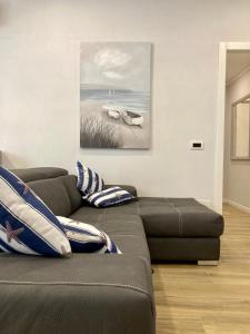 ein Wohnzimmer mit einem Sofa und einem Gemälde an der Wand in der Unterkunft CASA BEATRICE, trilocale Nuovo completamente arredato, compreso posto auto in Alassio