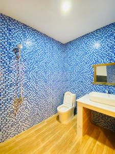 a blue tiled bathroom with a toilet and a sink at HOA Homestay Phu Quoc in Phu Quoc +35 photos