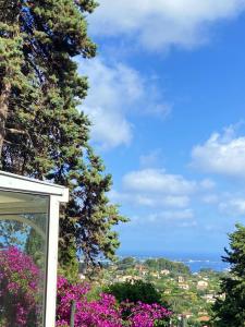 - une vue sur l'océan depuis une maison fleurie dans l'établissement Maison provençale vue mer, à Vallauris