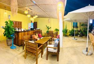 a restaurant with tables and chairs and an umbrella at HOA Homestay Phu Quoc in Phú Quốc