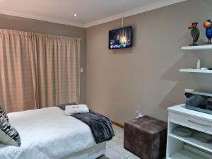 a bedroom with a bed and a tv on the wall at Hope Lodge in East London